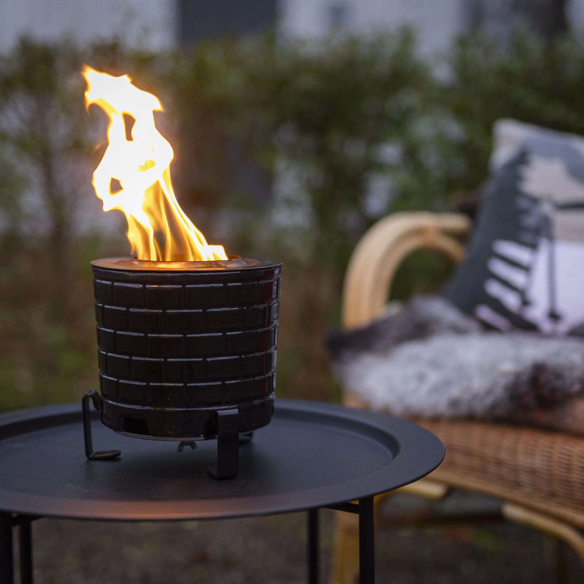 Stylish fire pit with flames in a cozy outdoor setting