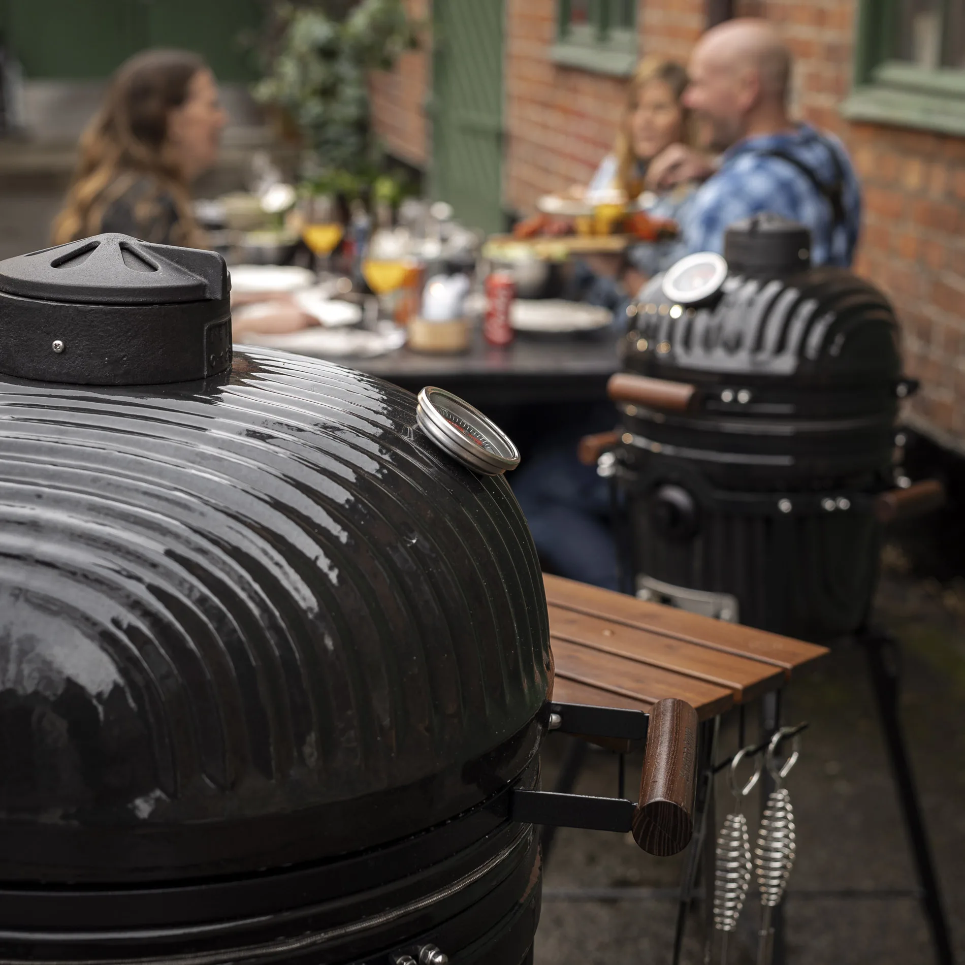Two Kamado Sumo ceramic grills in a dining setting