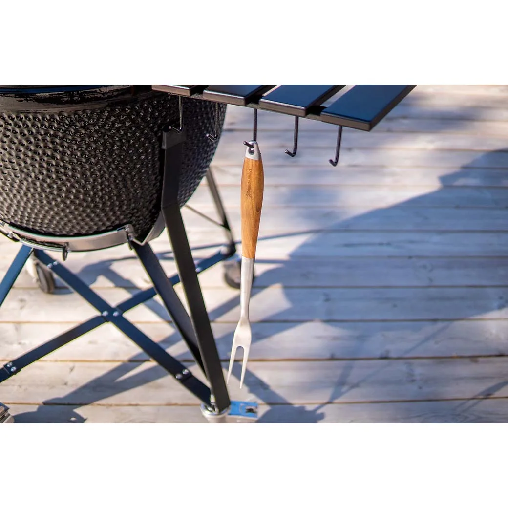 Kamado Sumo ceramic grill with a wooden-handled fork