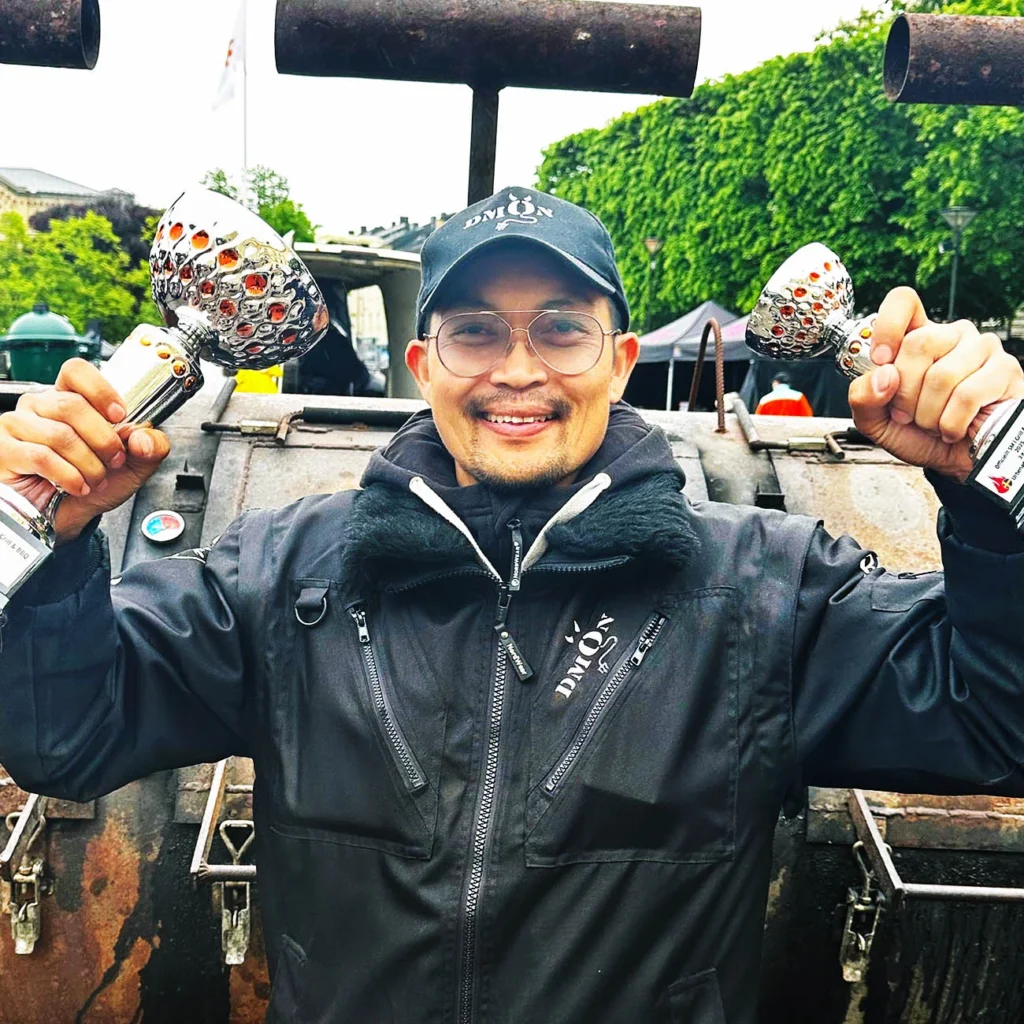 Grill master holding two trophies